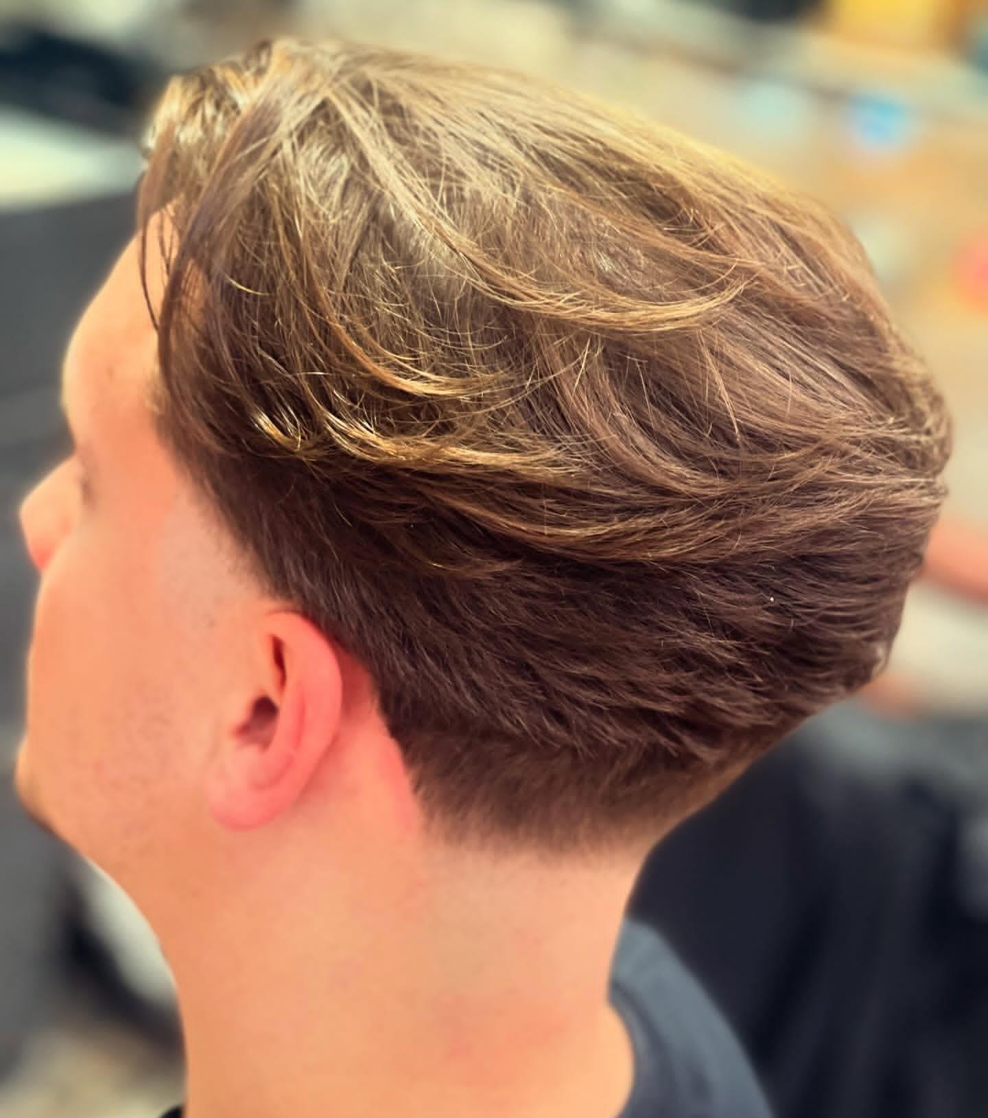 Textured layered cut with soft blonde highlights at Rio Barbers